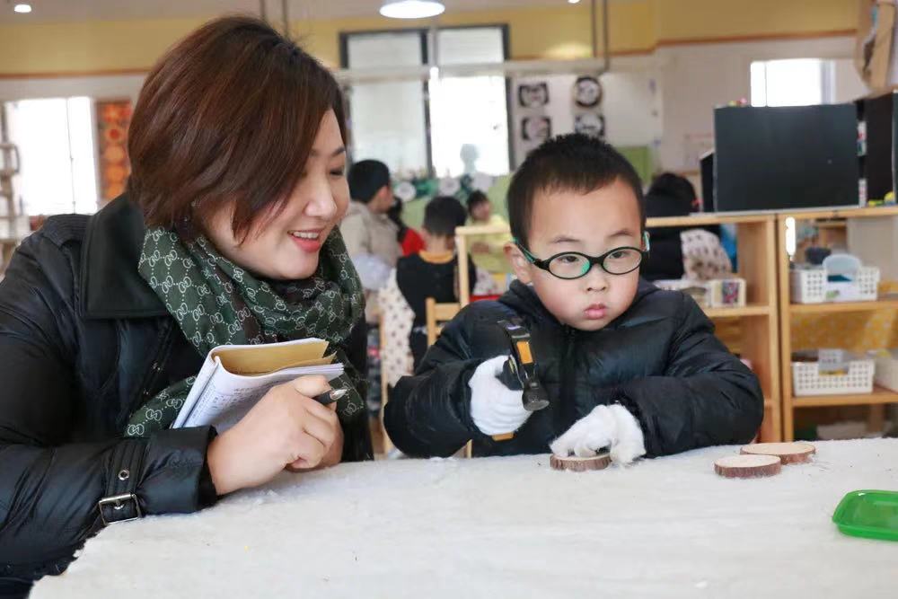 梁老师观察幼儿区域游戏.jpg